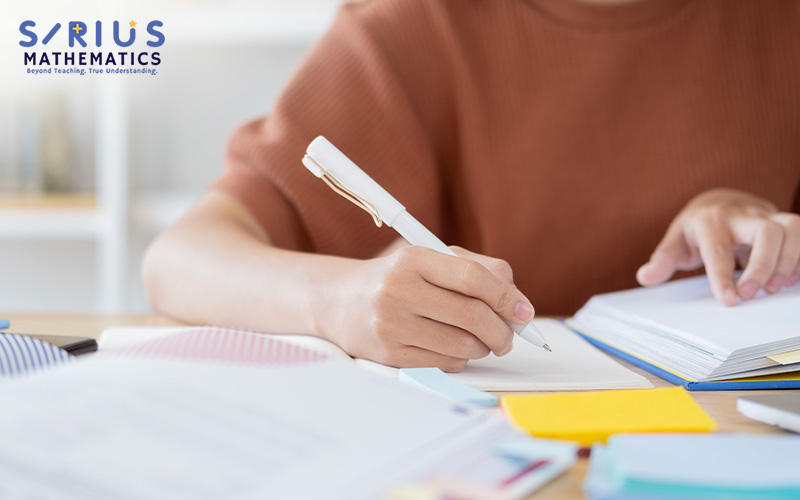 Sirius Mathematics student writing down solutions to math problems.