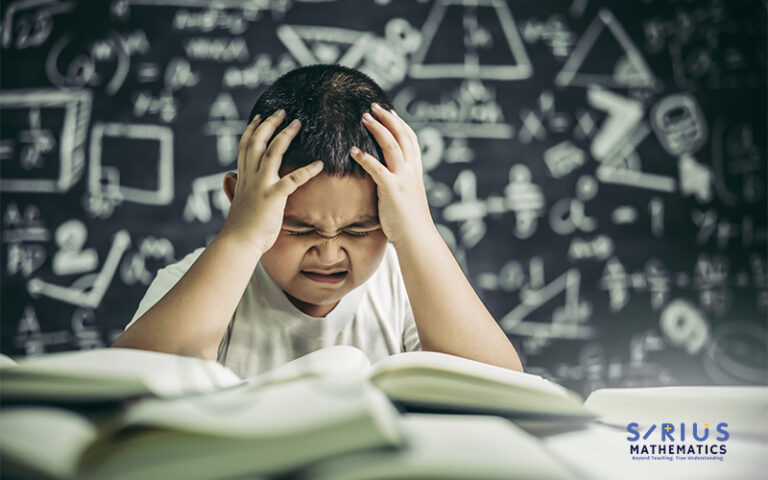 Student struggling with math equations on chalkboard.