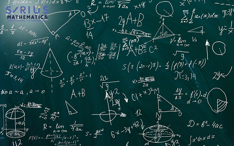 Chalkboard filled with advanced math equations, calculus notations, and geometric diagrams in a classroom.