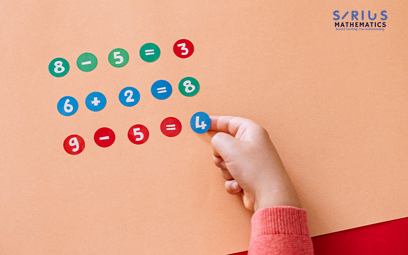 Child using number tokens to solve math equations.